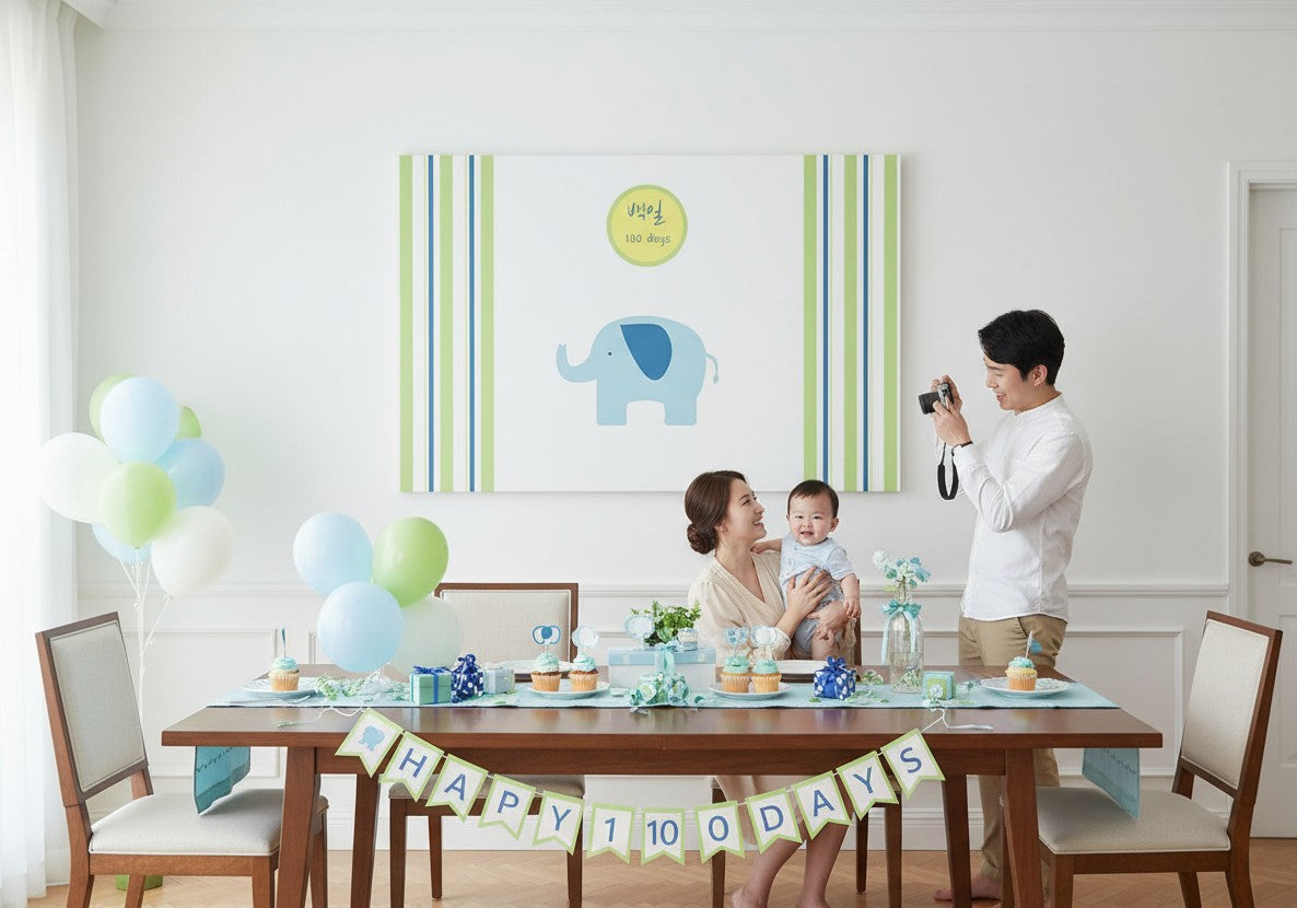 Little Seouls 100th Day Baek-il celebration banner with a blue elephant and green & blue stripes.