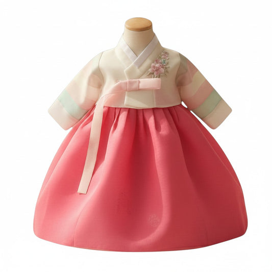 Little Seouls pastel and dark pink hanbok for a 100th day celebration. Features a cream top with floral embroidery and a pink skirt.