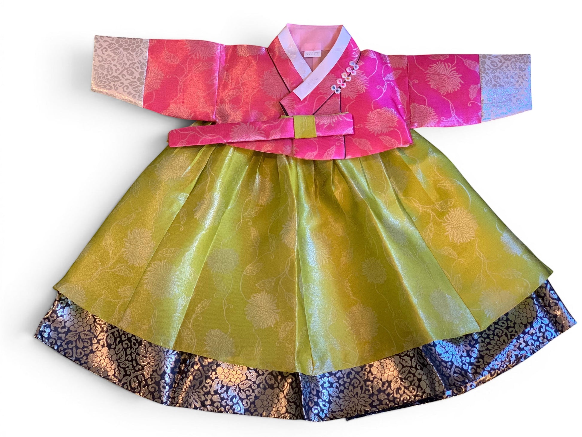 Little Seouls pink and lime green traditional Korean hanbok for a 1st birthday girl, with floral embroidery and ornate trim.