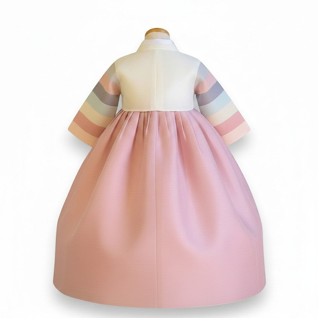 Little Seouls 100th Day Hanbok for baby girls, pastel pink skirt, white top with rainbow striped sleeves and white bow tie.