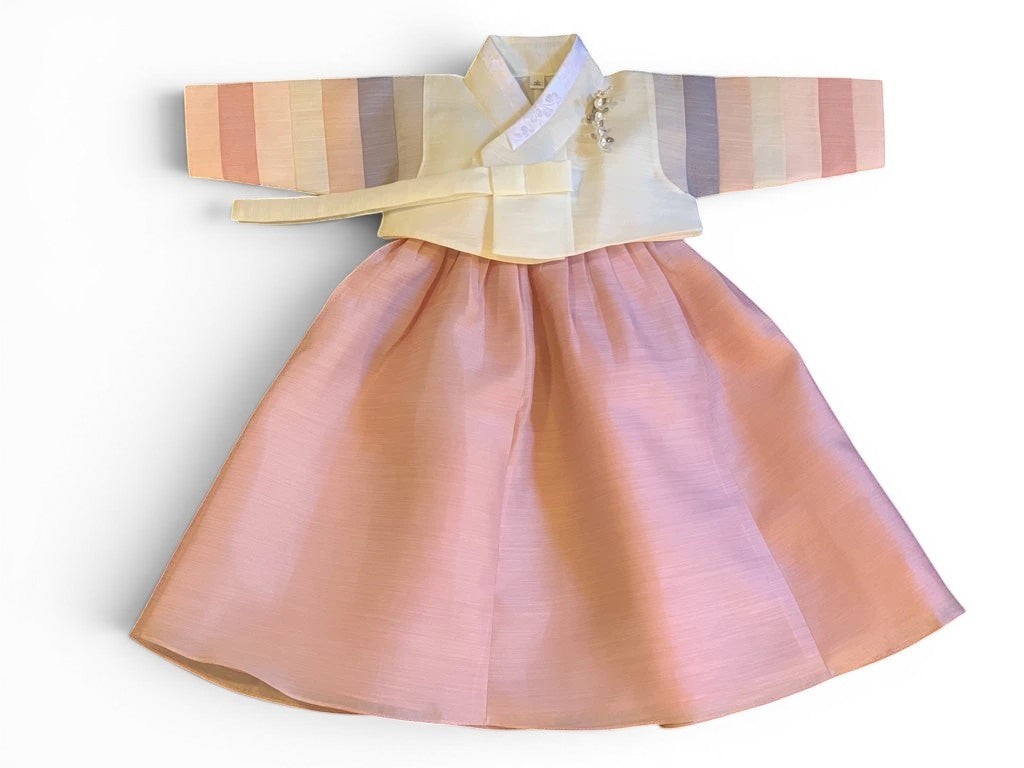 Little Seouls pastel striped sleeve 1st birthday girl's hanbok with a cream bodice and pink skirt.