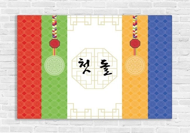 Little Seouls Traditional Korean First Birthday Celebration Banner in vinyl, featuring vibrant red, green, yellow, and blue bands with traditional patterns and Korean text '첫 돌'.