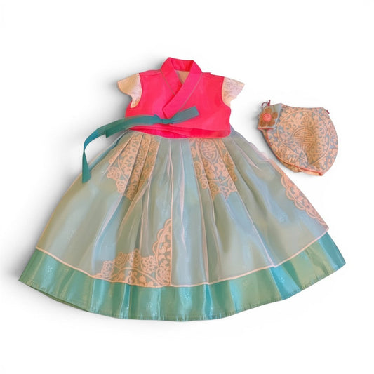 Little Seouls pink and blue fusion hanbok for a 1st birthday girl, featuring a bright pink top and a light blue skirt with white lace details. Includes a matching headpiece.