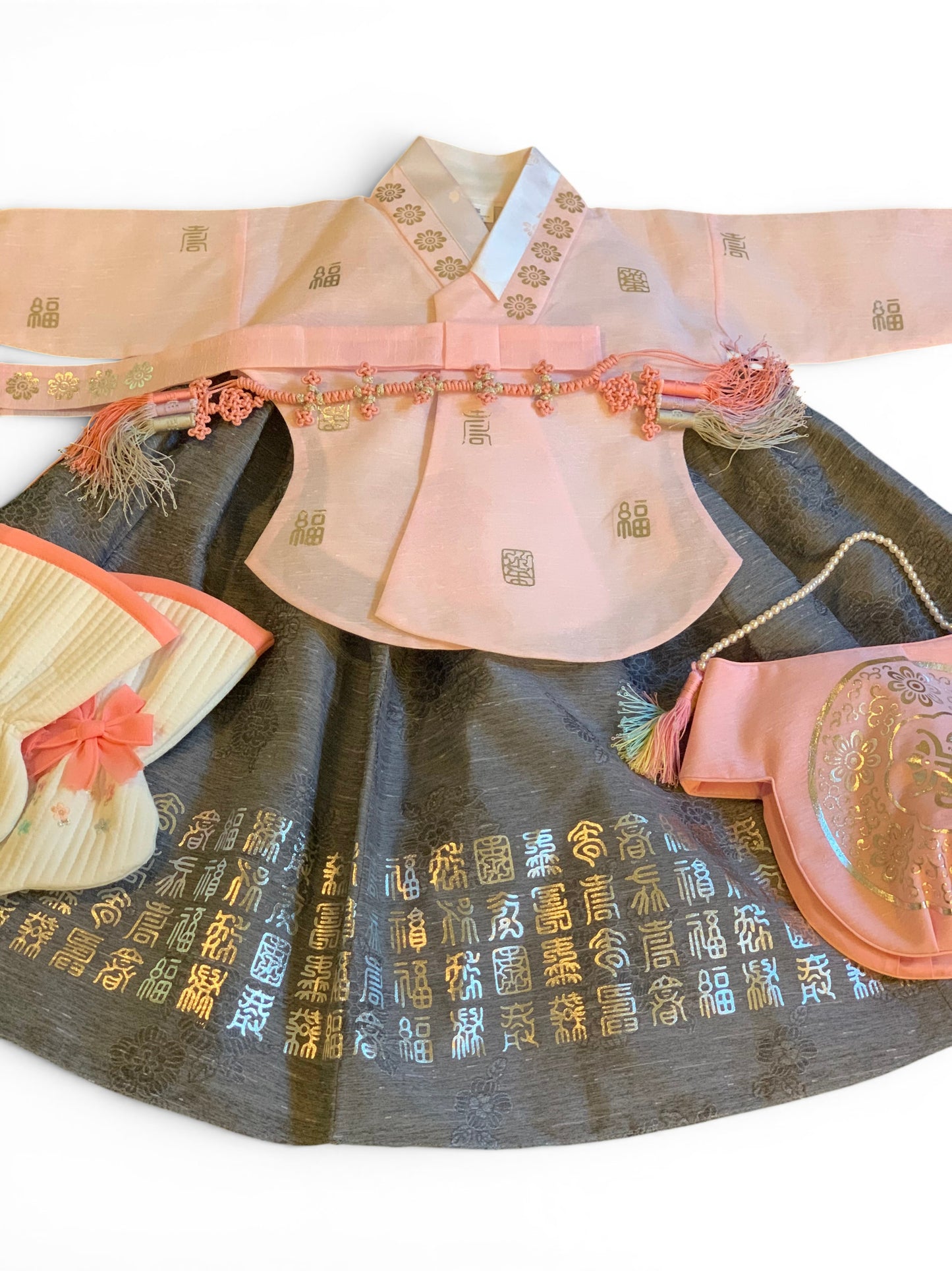 Little Seouls pink and gray Korean 1st birthday hanbok with intricate gold embroidery and a matching pink purse.