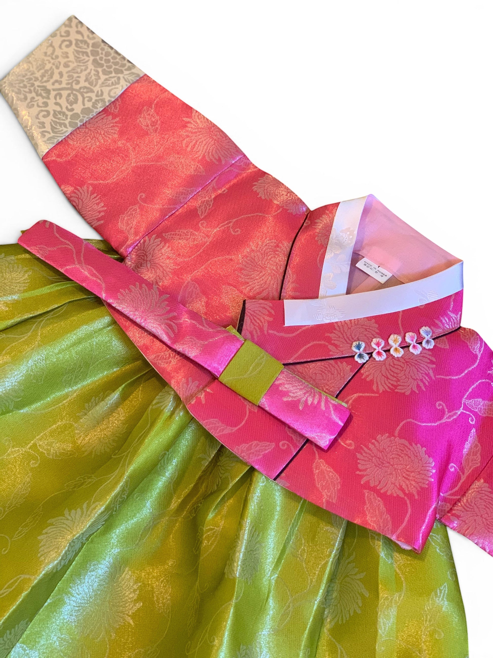 Little Seouls pink and lime green traditional Korean hanbok for a 1st birthday girl. Features floral embroidery and decorative buttons.