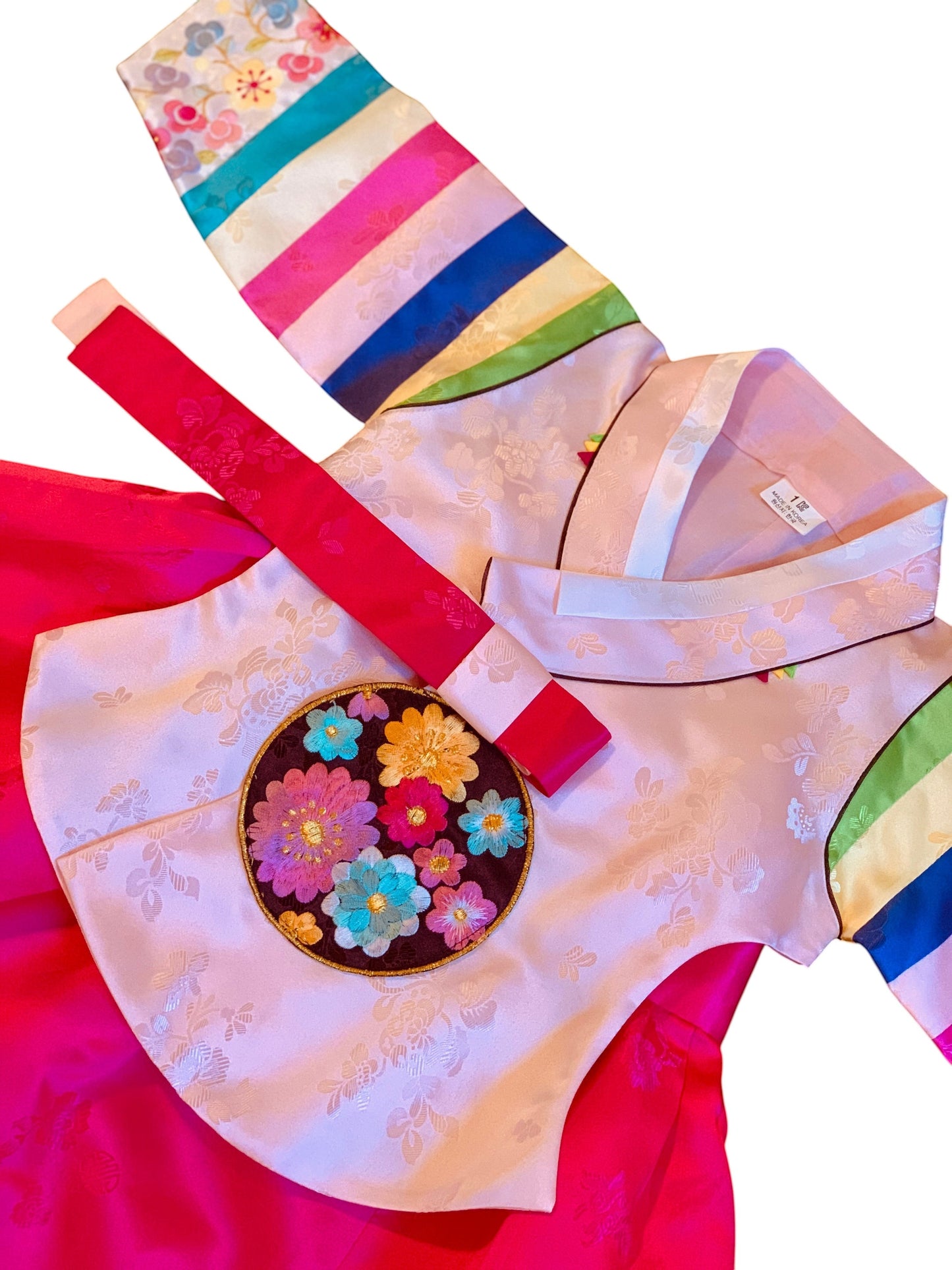 Little Seouls 1st birthday girl's pink palace hanbok with embroidered floral detail and rainbow sleeves.